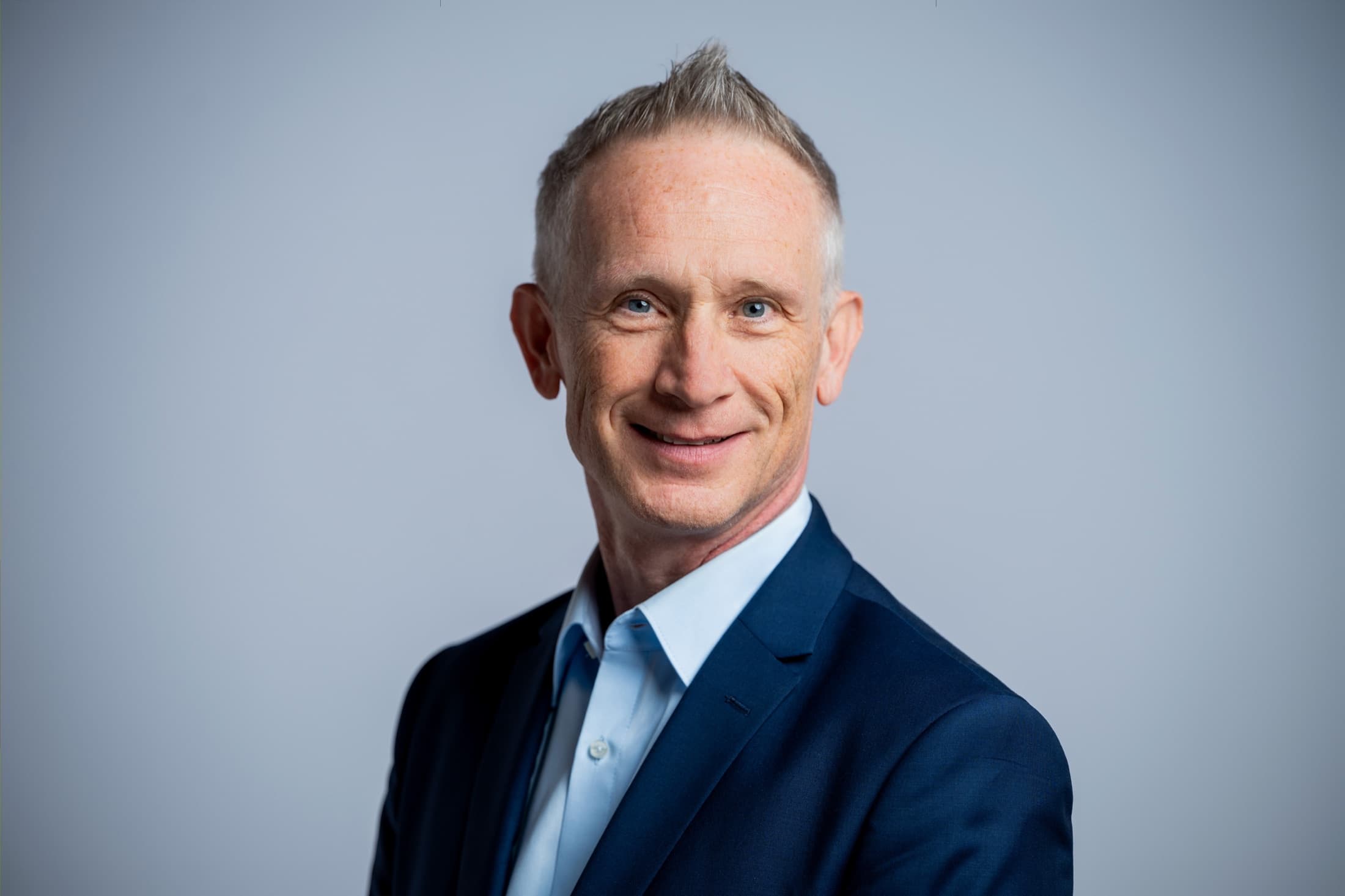 Jürgen Kob Portrait im blauen Anzug vor hellem Hintergrund
